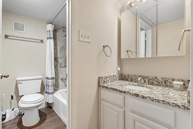 a bathroom with a granite countertop sink toilet and shower