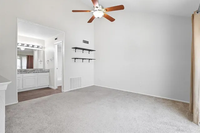 an empty room with cabinet and windows