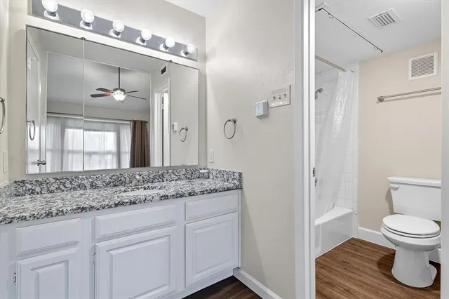 a bathroom with a granite countertop sink toilet and shower