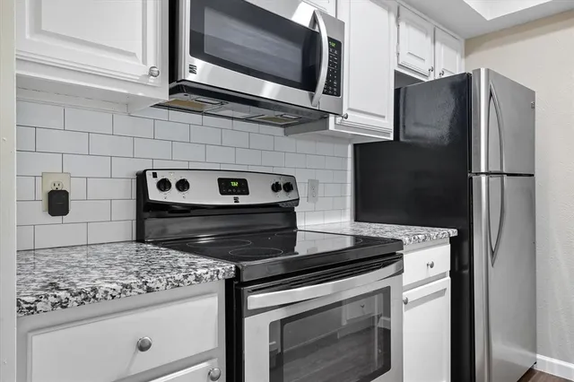 a kitchen with granite countertop cabinets and steel stainless steel appliances