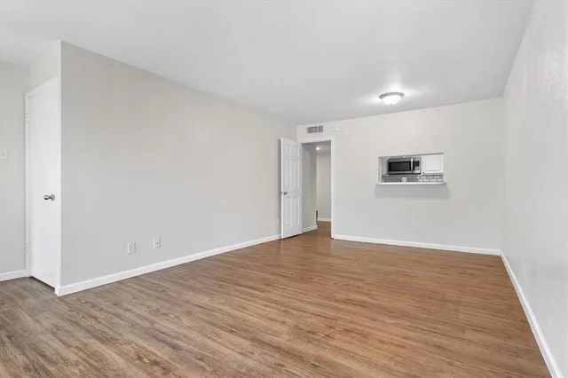 a view of an empty room with wooden floor