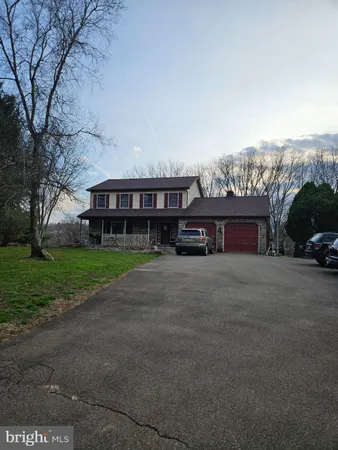 a view of house with a yard and car parked