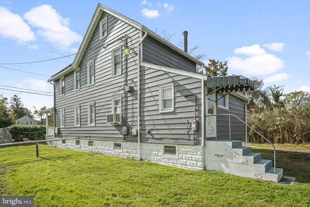 a view of house with backyard and sitting area