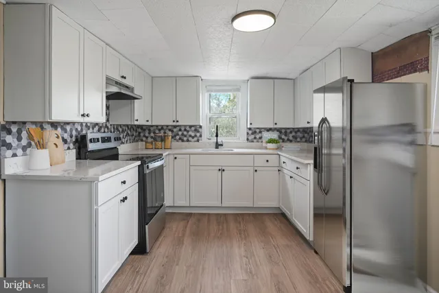 a kitchen with a sink a refrigerator and cabinets