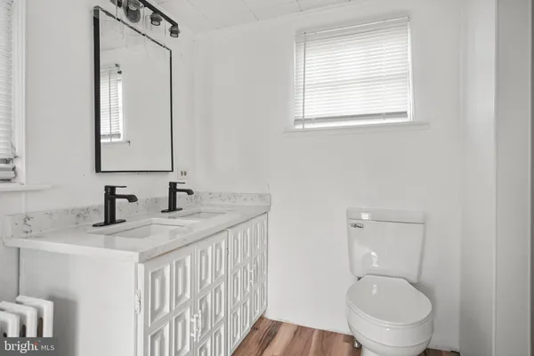 a bathroom with a granite countertop toilet sink and mirror