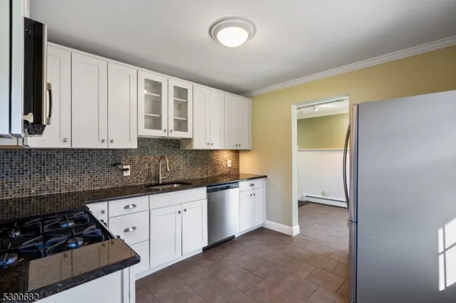 a kitchen with granite countertop a stove a sink and a refrigerator