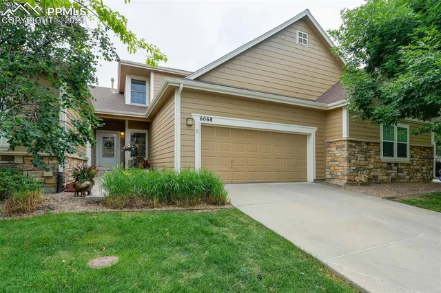 a front view of a house with a garden and yard