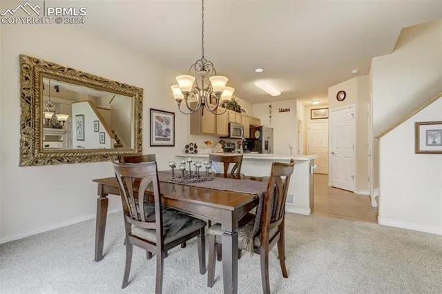 a view of a dining room with furniture and a chandelier