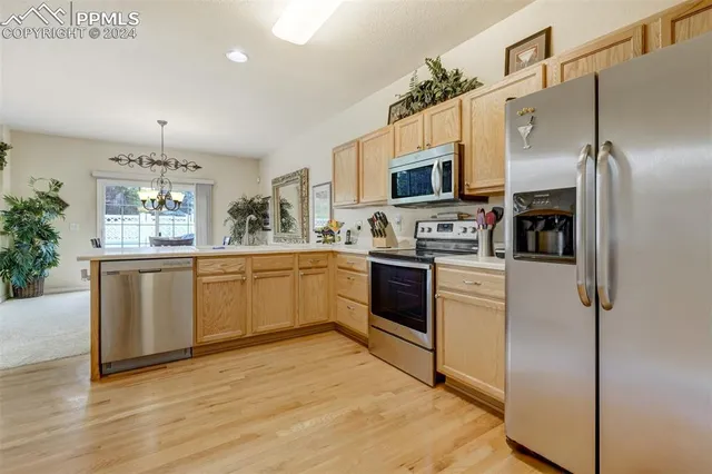 a kitchen with a sink cabinets stainless steel appliances and a window