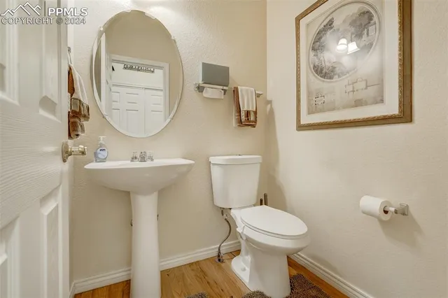 a bathroom with a toilet a sink and mirror