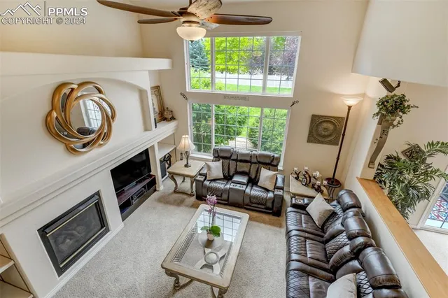 a living room with furniture a fireplace and a floor to ceiling window