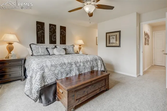 a bedroom with a bed and lamp on desk