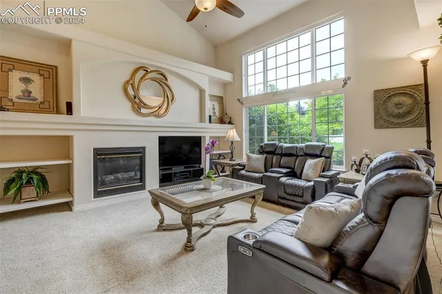 a living room with furniture a fireplace and a large window
