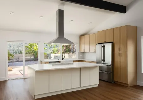 a kitchen with stainless steel appliances a sink a stove a refrigerator and wooden floor