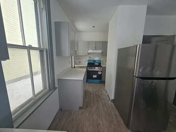 a kitchen with a refrigerator a stove and a window