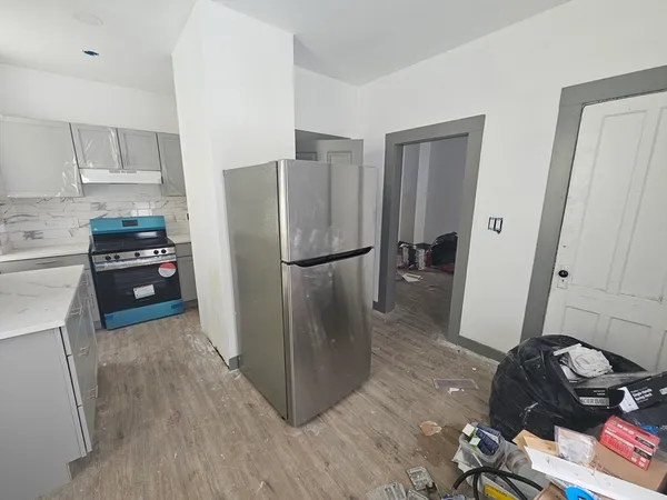 a kitchen with stainless steel appliances a refrigerator a stove a sink and a hard wood floors
