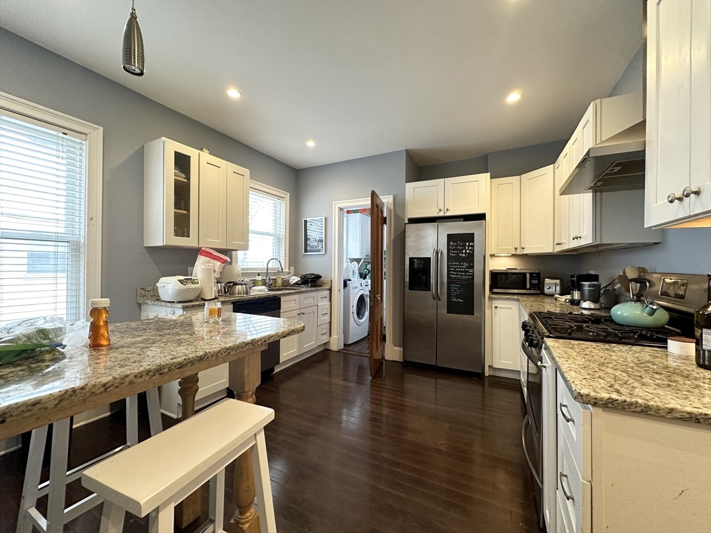 a large kitchen with stainless steel appliances kitchen island granite countertop a large center island and a sink
