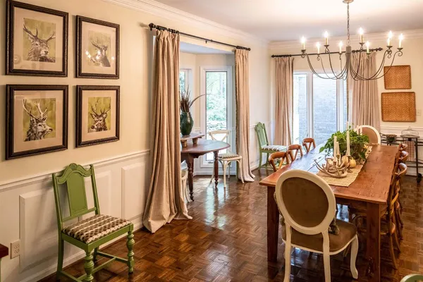 a kitchen with stainless steel appliances granite countertop a refrigerator a stove and a dining table with wooden floor