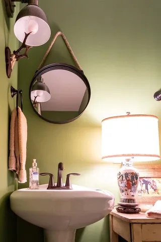 a bedroom with a bed and a lamp on dresser