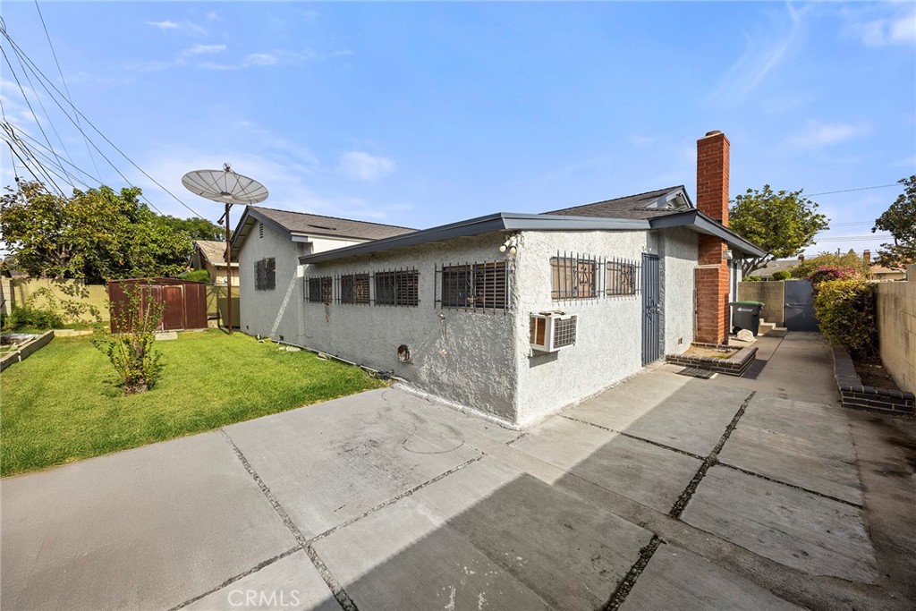 19409 Belshaw Avenue Carson, CA 90746 - Photo 14 of 15 a front view of a house with a yard and potted plants