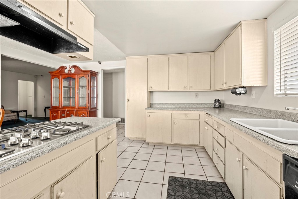 19409 Belshaw Avenue Carson, CA 90746 - Photo 10 of 15 a kitchen with a sink stove and cabinets