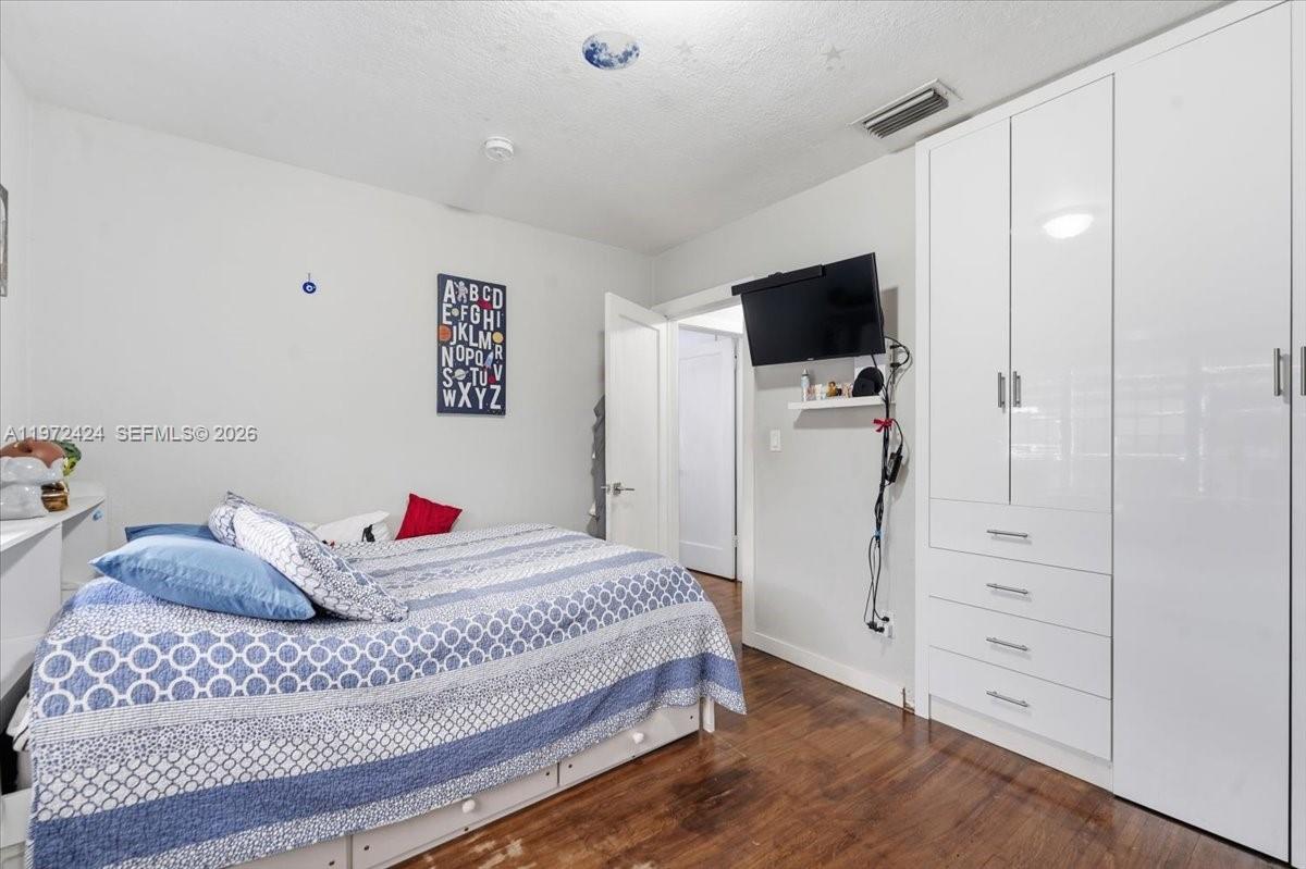 511 East 27th Street Hialeah, FL 33013 - Photo 12 of 24 a bedroom with a bed and a flat screen tv