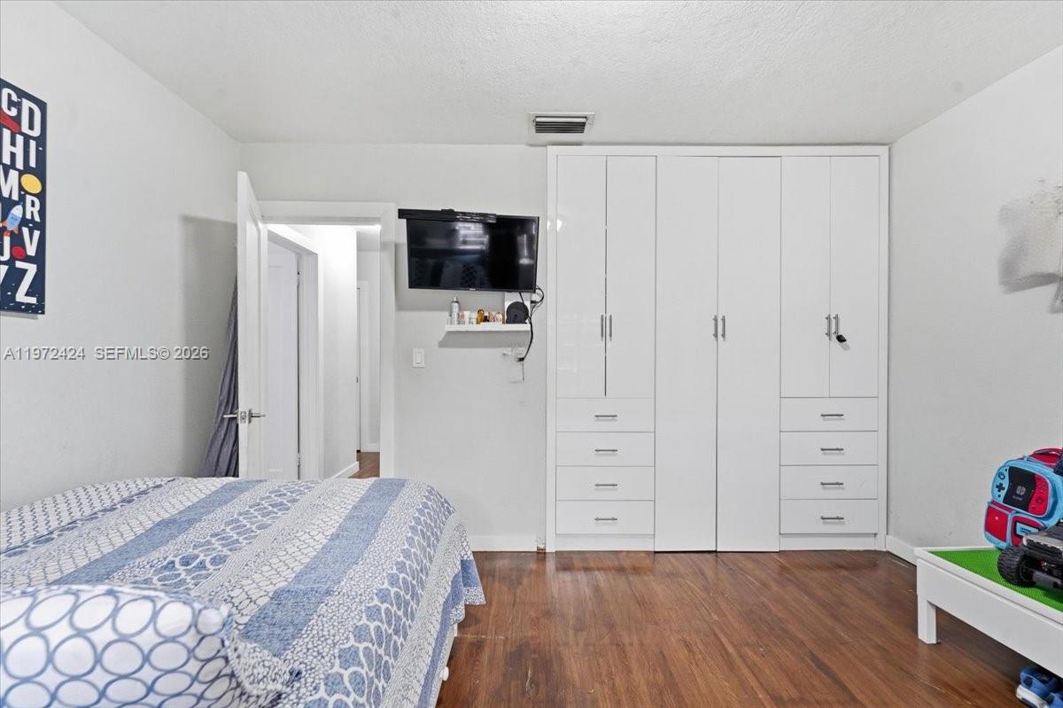 511 East 27th Street Hialeah, FL 33013 - Photo 13 of 24 a bedroom with a bed and a flat screen tv