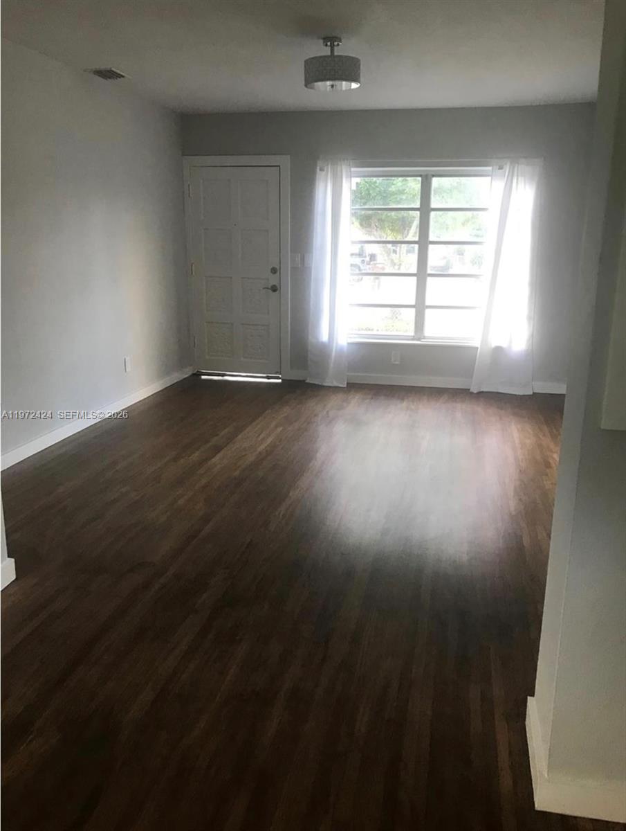 511 East 27th Street Hialeah, FL 33013 - Photo 14 of 24 an empty room with wooden floor and windows