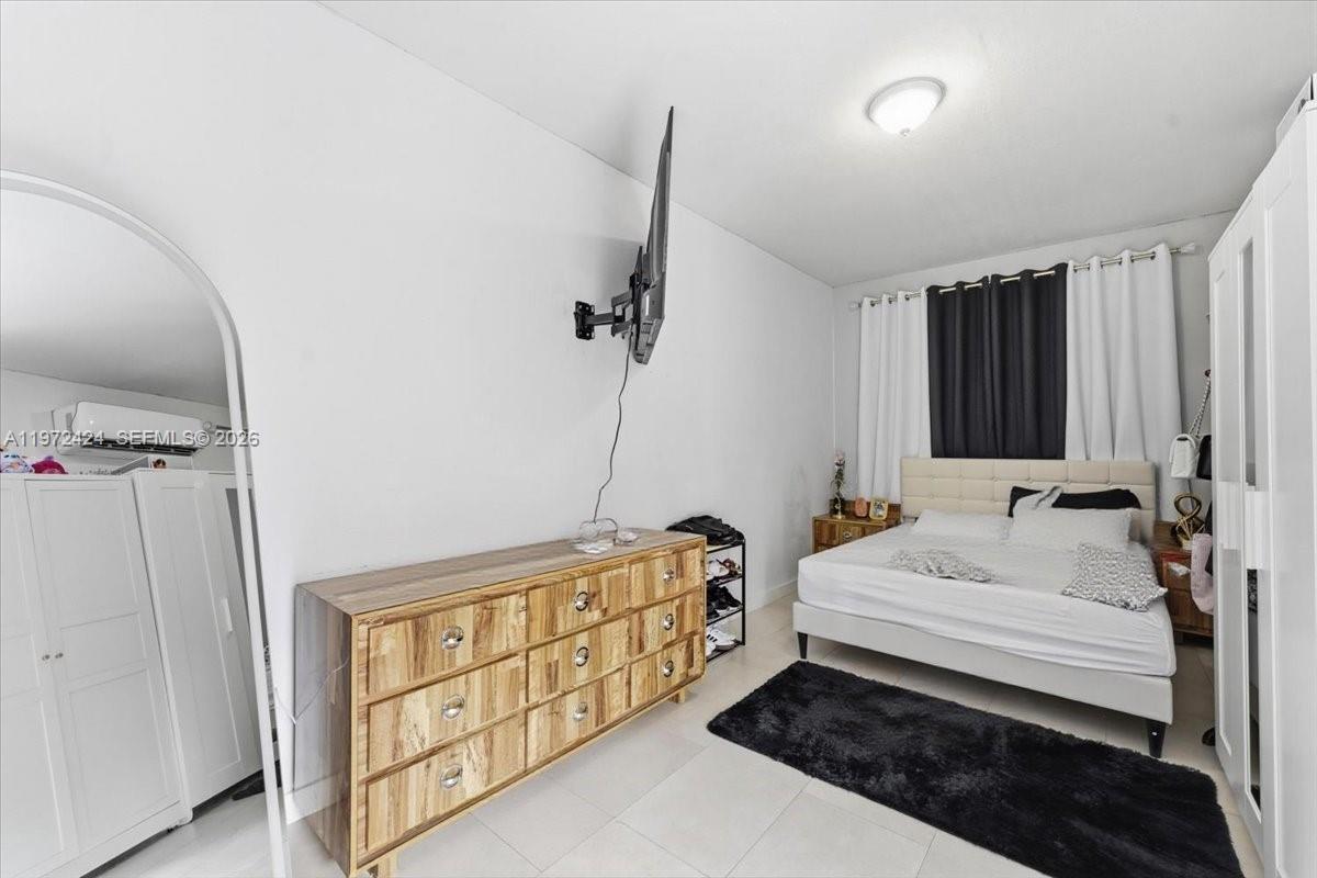 511 East 27th Street Hialeah, FL 33013 - Photo 15 of 24 a bedroom with a bed a dresser and a window