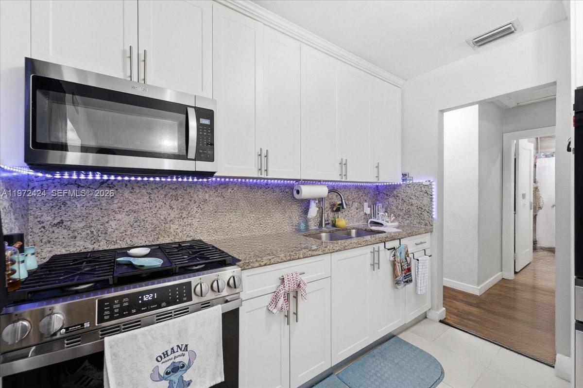 511 East 27th Street Hialeah, FL 33013 - Photo 6 of 24 a kitchen with granite countertop a stove and a microwave