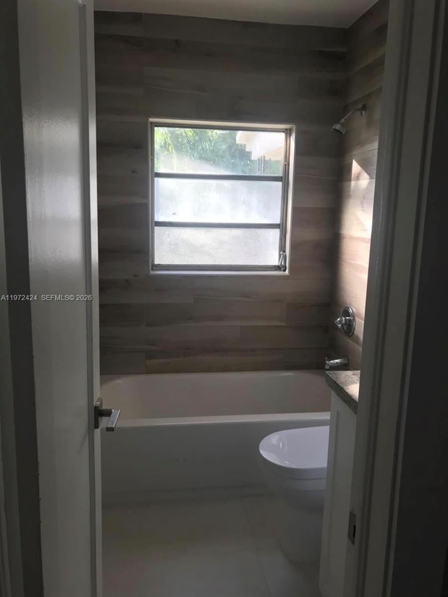 511 East 27th Street Hialeah, FL 33013 - Photo 9 of 24 a bathroom with a toilet and a bath tub