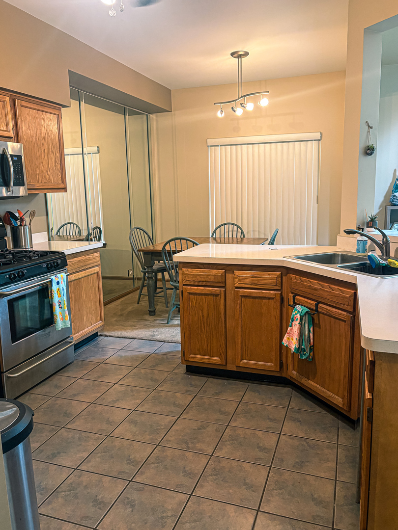 1567 Spaulding Road, Unit 1567 Bartlett, IL 60103 - Photo 7 of 13 a kitchen with kitchen island granite countertop a stove a sink and a refrigerator