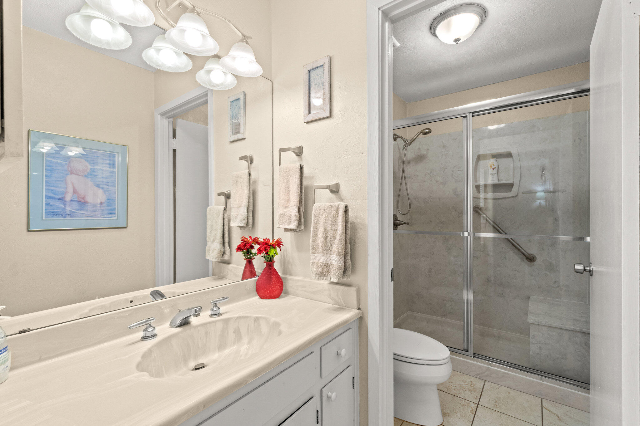 752 Sandpiper Drive, Unit 10535 Miramar Beach, FL 32550 - Photo 13 of 32 a bathroom with a shower sink vanity mirror and toilet