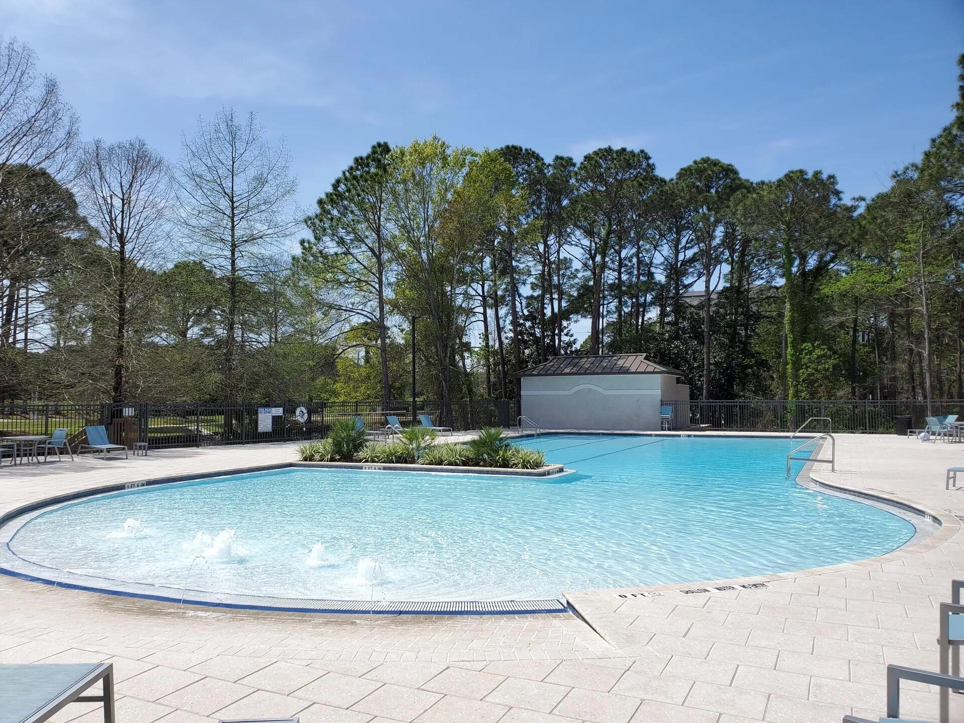 752 Sandpiper Drive, Unit 10535 Miramar Beach, FL 32550 - Photo 21 of 32 a view of a swimming pool with a yard and large trees