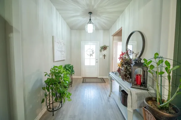 a vase of flowers sitting on a floor in front of a door