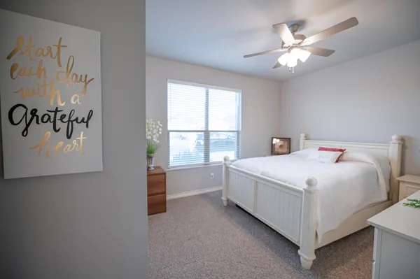a white bed sitting in a bedroom next to a window