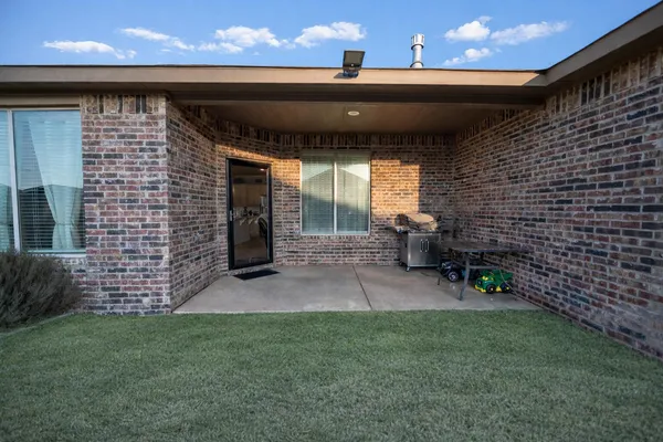a view of a patio with table and chairs with wooden fence