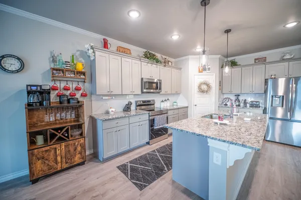 a kitchen with kitchen island granite countertop wooden cabinets and a stove