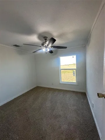 an empty room with a window and a fan