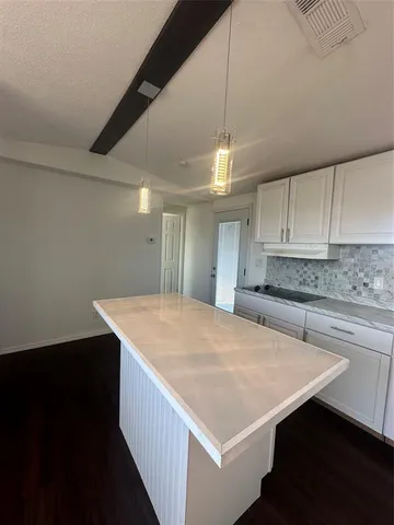 a kitchen with a sink a counter space and a refrigerator