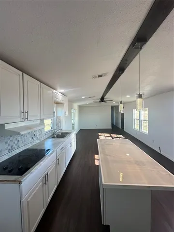 a kitchen with sink a stove and cabinets