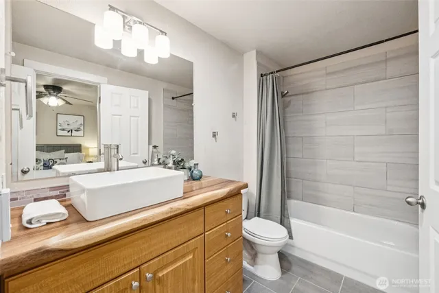 a bathroom with a sink a toilet a mirror and bathtub