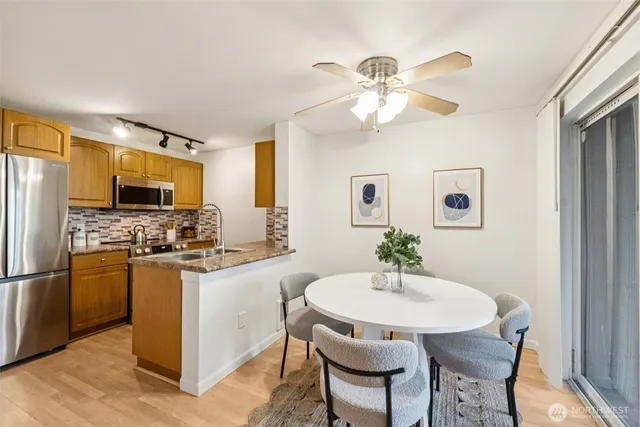 a kitchen with stainless steel appliances a stove a table and chairs