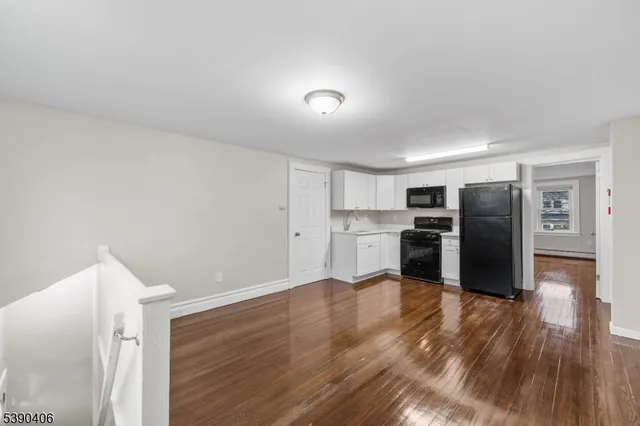 a view of kitchen refrigerator and wooden floor