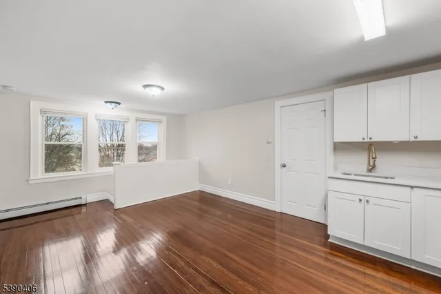a view of a kitchen with wooden floor and cabinets