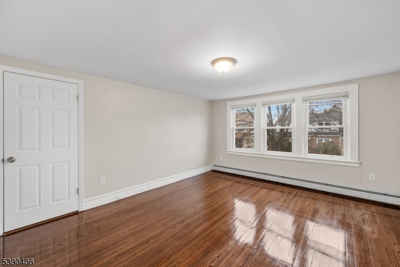 76 Van Ness Terrace, Unit 2 Maplewood, NJ 07040 - Photo 6 of 9 a view of an empty room with wooden floor and a window