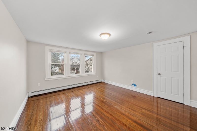 76 Van Ness Terrace, Unit 2 Maplewood, NJ 07040 - Photo 7 of 9 a view of an empty room with wooden floor and a window
