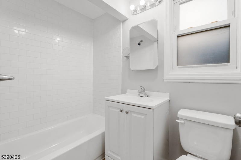 76 Van Ness Terrace, Unit 2 Maplewood, NJ 07040 - Photo 8 of 9 a bathroom with a toilet sink and mirror