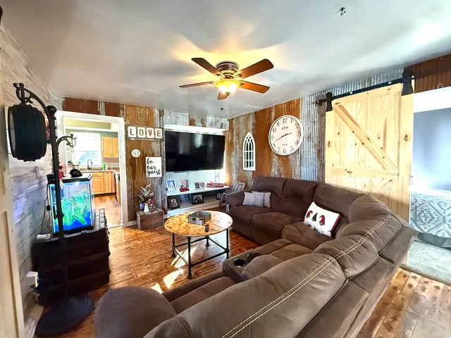 a living room with furniture a flat screen tv and a large window
