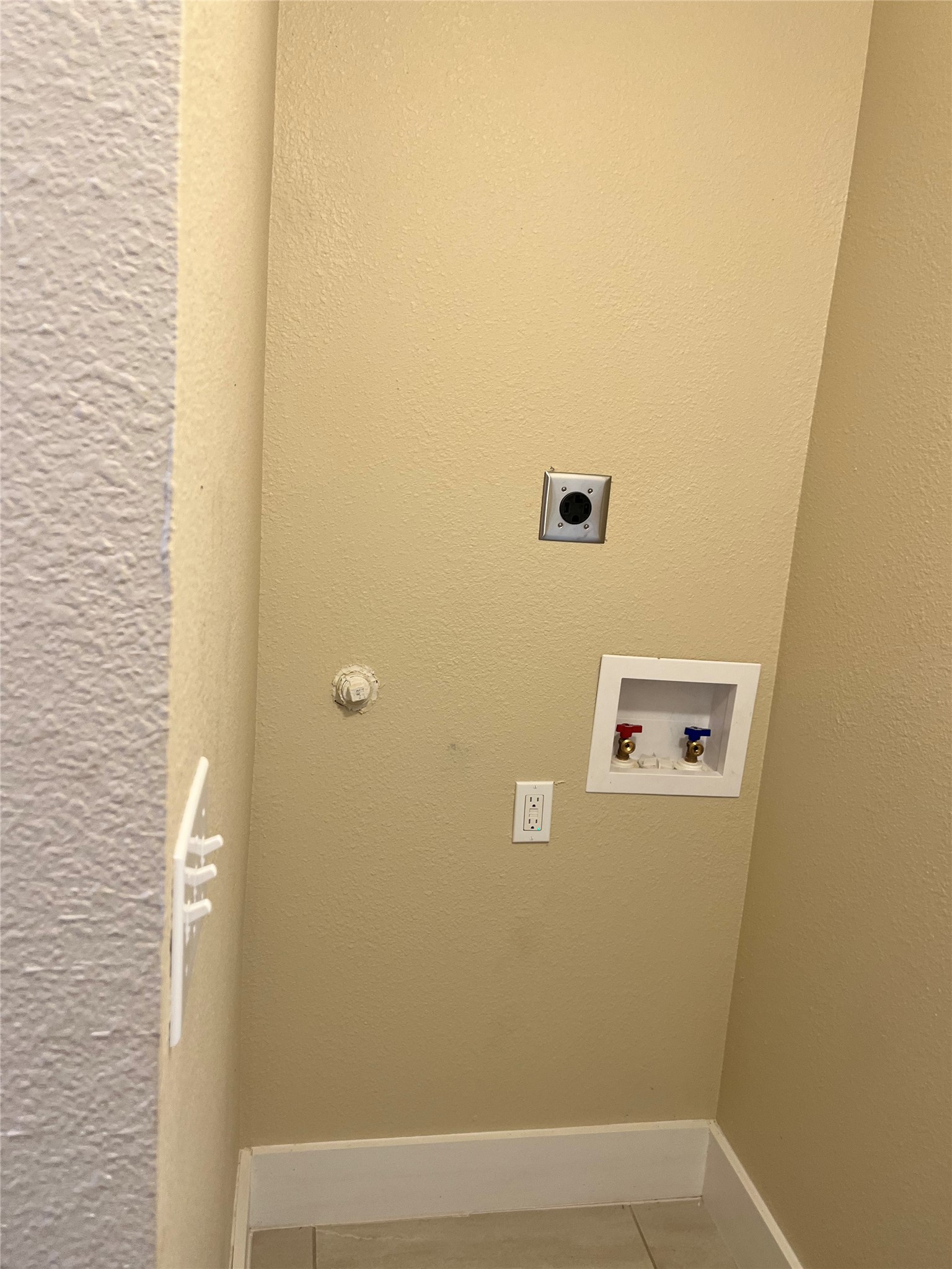 1565 Pump Station Road, Unit B Wimberley, TX 78676 - Photo 11 of 12 Laundry area with a textured wall, tile patterned floors, washer hookup, and hookup for an electric dryer